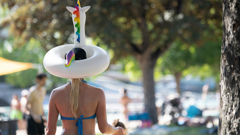 Eine Frau trägt einen Einhorn-Schwimmring auf dem Kopf.