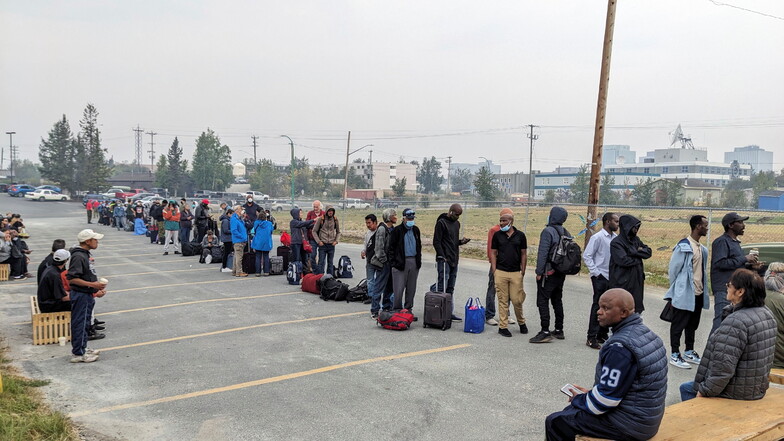 Menschen ohne Fahrzeug stehen in Yellowknife an, um sich für einen Evakuierungs-Flug nach Calgary, Alberta, zu registrieren.