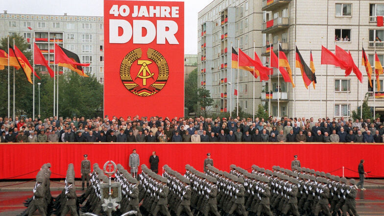 Das Archivbild zeigt Soldaten der Nationalen Volksarmee während der Militärparade in Ost-Berlin vor der Tribüne mit der Regierung und den Ehrengästen auf der Karl-Marx-Allee. Die Führung der DDR feierte die Gründung der Deutschen Demokratischen Republik v