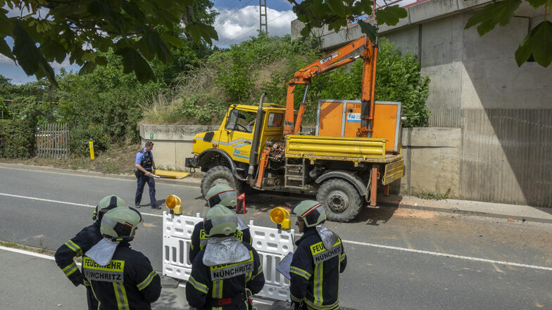 Die Polizei misst die Unfallstelle aus. Zuvor haben Nünchritzer und Grödeler Feuerwehrleute Bindemittel unter dem Unimog verteilt, um auslaufendes Öl zu binden.  