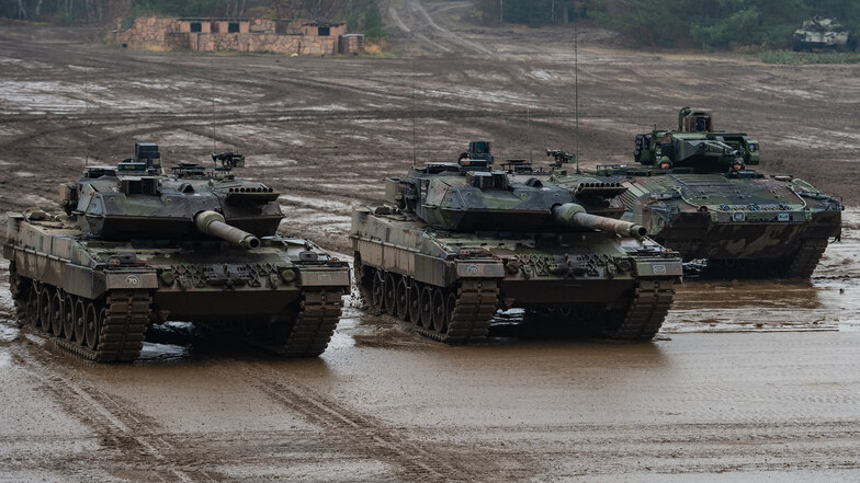Zwei Kampfpanzer der Bundeswehr, vom Typ Leopard 2A6 und ein Schützenpanzer vom Typ Puma fahren bei einer Übung durchs Gelände.