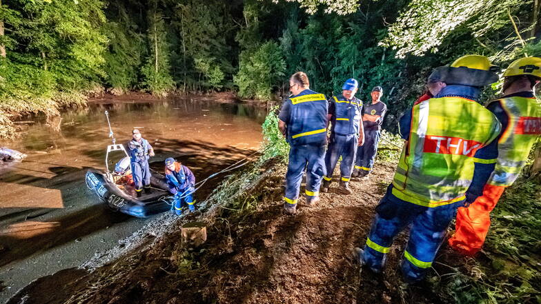 Rettungskräfte sichern einen Teich bei Fröndenberg dessen Deich durch sintflutartige Regenfällen aufgeweicht wurde und zu brechen droht.