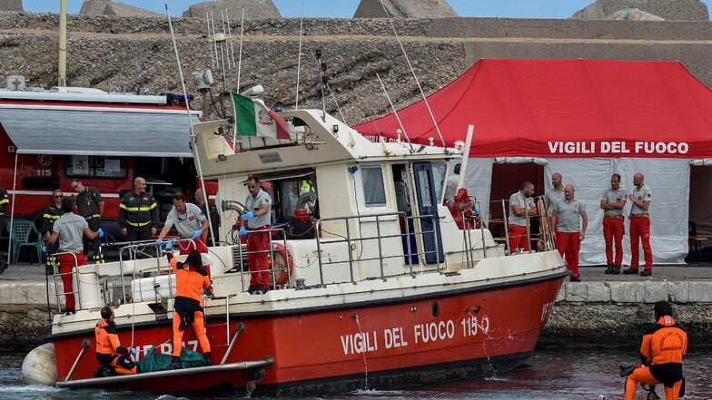 Taucher der italienischen Feuerwehr bringen die Leiche eines der Opfer des unter britischer Flagge fahrenden Schiffes «Bayesian», in einem grünen Sack an Land.