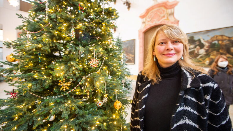 Schlosschefin Dominique Fliegler neben einem von mehreren Weihnachtsbäumen mit Glasperlen-Schmuck aus Nordböhmen, der für zusätzlichen Glanz sorgt. Der besondere Schmuck ist seit 2020 immaterielles Kulturerbe.
