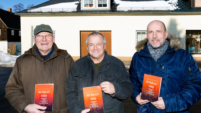 Karl-Heinz Boden, Mathias Hüsni und Dietmar Kindlein (von links) sind die Autoren des Buches „Burkau 1945“. Hinter ihnen ist das ehemalige Spritzenhaus zu sehen. Während eines Todesmarsches 1945 wurden dort Gefangene untergebracht.