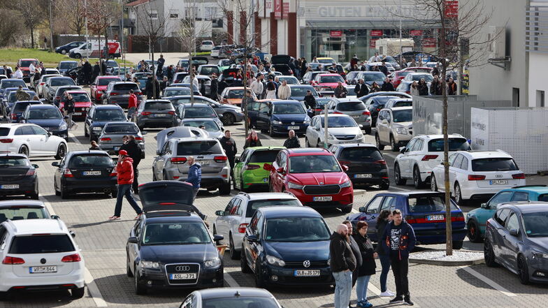 Fans der Tuningszene stehen mit ihren Autos auf einem Parkplatz in Blankenburg.