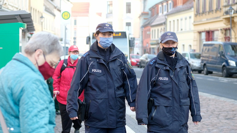 Die Bürgerpolizistinnen Ramona Lundershausen und Tatjana Iltzsche laufen Coronastreife in der Innenstadt von Meißen. Die Anzahl der Neuinfektionen ist am Donnerstag gegenüber dem Vortag stark zurückgegangen. Vermutlich ist das aber nur ein Feiertags-E
