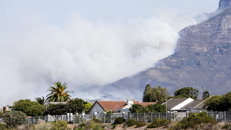 Weißer dichter Rauch steigt über dem Tafelberg auf.