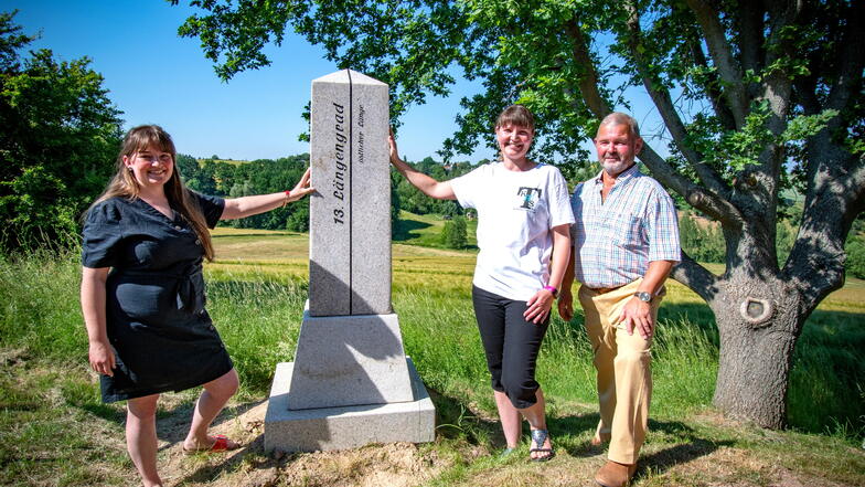 Karla Just, Bianca Ulbricht und Gerd Pfeifer stehen am Obelisk, der auf den 13. Längengrad östlicher Länge hinweist.