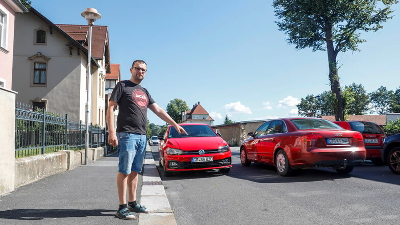 Frank Heidrich zeigt die Straße vor der Wohnung seiner Familie in Zittau. Hier wurde in der Nacht zum 17. Juli das Auto der Familie gestohlen.