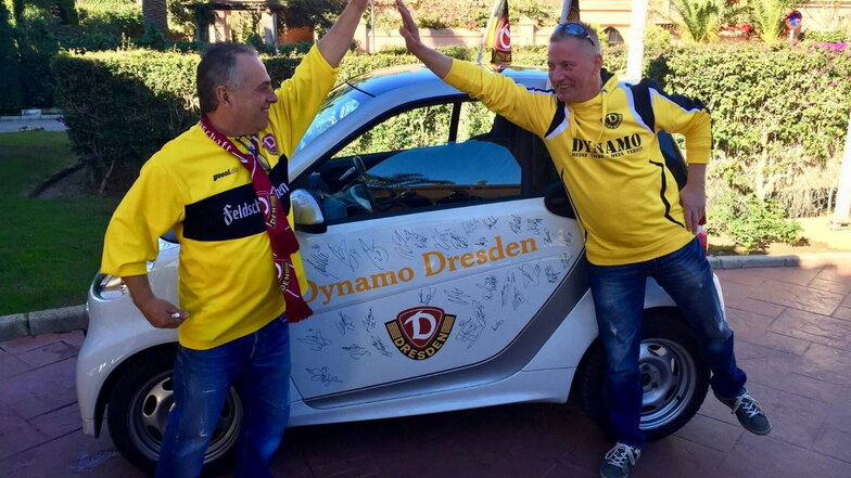 Fernando Hayn (links) mit seinem Bruder Norbert vor seinem Smart. Seit 2017 zieren das Auto nicht nur Dynamo-Embleme und Schriftzüge, sondern auch die Autogramme aller damaliger Dynamo-Spieler.
