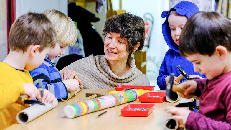 Anke Schulz-Broschwitz bastelt in kleiner Gruppe mit Kindern in der Holzwerkstatt des Ökumenischen Kinderhauses. Sie schenkt den vier Jungen mehr Aufmerksamkeit.
