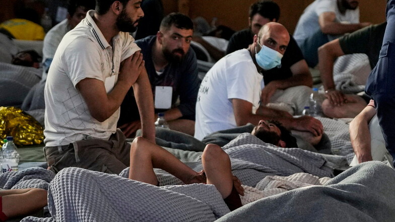 Überlebende des Bootsunglücks schlafen in einem Lagerhaus im Hafen der Stadt Kalamata.