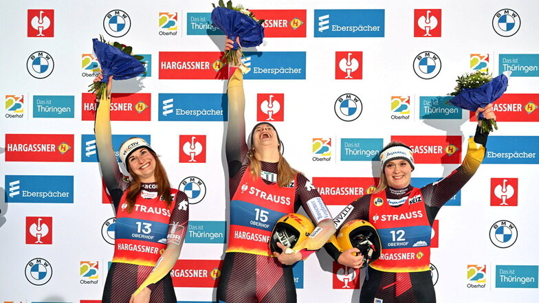 Deutscher Dreifach-Triumph: Weltmeisterin Dajana Eitberger (M) jubelt auf dem Podest, Julia Taubiitz (l) freut sich über Silber und Anna Berreiter (r) ist Dritte.