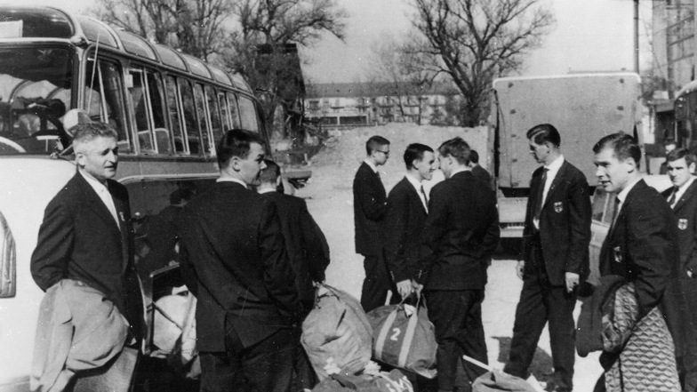 Eigentlich sollten sie auf dem Eis stehen, aber die westdeutschen Spieler warten am Bus vor dem Stadion in Genf. Auf politischen Beschluss boykottiert die BRD das Spiel gegen die DDR zum Abschluss der Weltmeisterschaft.