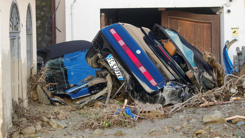 Zwei von Schlamm bedeckte Autos liegen vor einen Wohnhaus in Casamicciola.