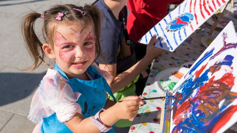 Beim Familienfest auf dem Marienplatz in Görlitz malt die dreijährige Maya einen Dinosaurier.