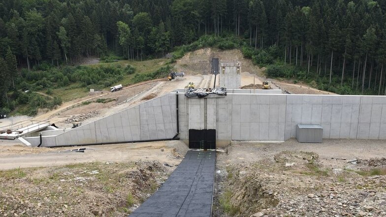 Das Bild von der anderen Seite der Anlage zeigt die Mauer aus Asphaltbeton in der Mitte des Damms, die ihn wasserdicht macht.