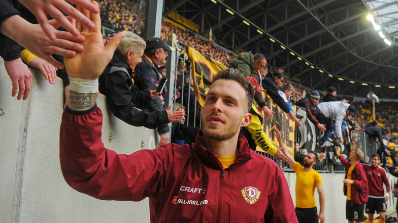 Patrick Schmidt klatscht nach dem Sieg im Sachsenderby gegen Erzgebirge Aue mit Dynamo-Fans ab - das Rudolf-Harbig-Stadion war bei dem Spiel zum bislang letzten Mal voll besetzt.