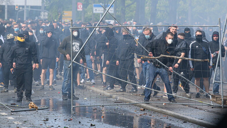 Steine und Flaschen fliegen am 16. Mai vor dem Dynamo-Stadion auf Polizisten. Nun wird gegen hunderte Gewalttäter ermittelt.
