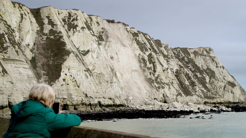 Eine Frau fotografiert die weißen Klippen nahe Dover, die eingestürzt sind. Ein großer Brocken der berühmten weißen Klippen nahe Dover ist in den Ärmelkanal gestürzt.