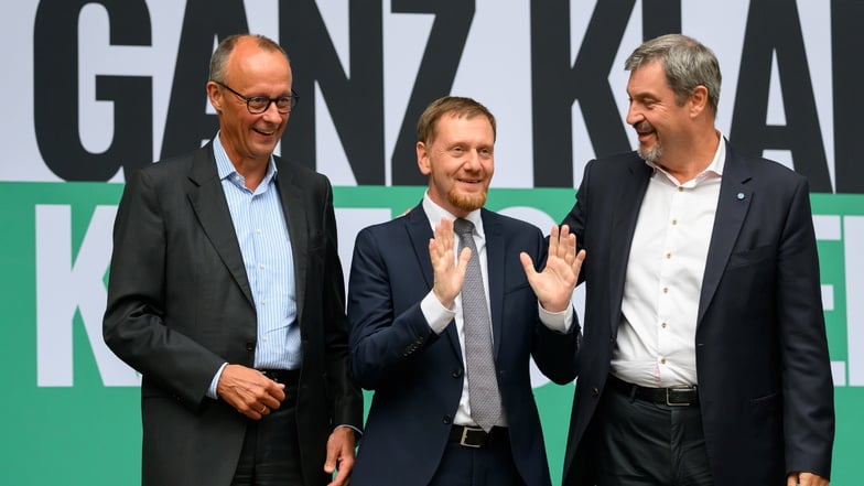 Michael Kretschmer (M.) baut im Wahlkampf auf die Unterstützung von Friedrich Merz (l.) und Markus Söder.