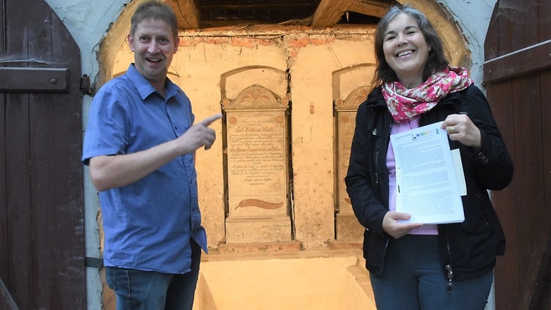 Karin Noack und Frank Dutsch mit der Dokumentation zur Rekonstruktion und Sanierung der Gruft am Zugang an der Evangelischen Jakobskirche.