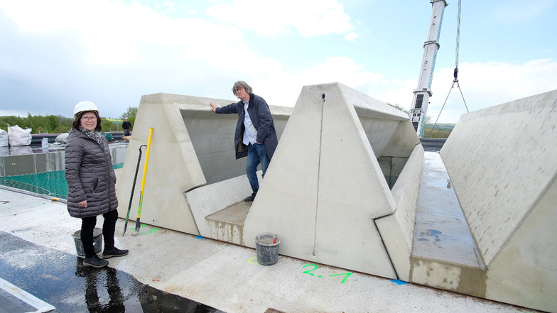 Architekt Knut Hauswald erklärt die Funktion der Stahlbeton-Dachelemente der neuen Oberschule in Klipphausen. Gemeinsam mit Bauamtsleiterin Elvira Grübler schaut er sich den Baufortschritt an.