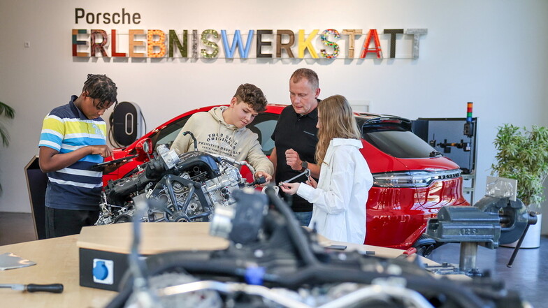 Ausbilder Lars Bergemann erläutert Schülern einen 4-Zylinder-Boxermotor in der Porsche Erlebniswerkstatt in Leipzig.