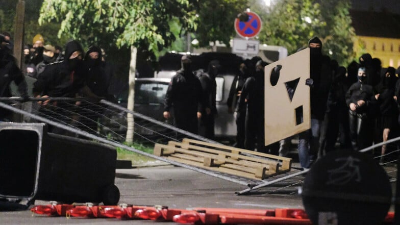 Teilnehmer der linken Demonstration legen Gegenstände als Barrikade auf eine Straße. v