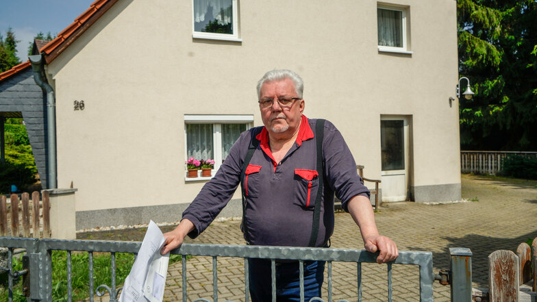 Roland Hornig steht am Zaun seines Grundstückes in Großharthau. In der Nacht zum Freitag wurde auf sein Haus ein Brandanschlag verübt. An der Tür rechts sind die Spuren deutlich zu sehen.