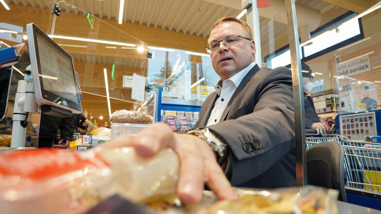 Neukirchs Bürgermeister Jens Zeiler versuchte sich am Donnerstag als Supermarkt-Kassierer - für einen guten Zweck.