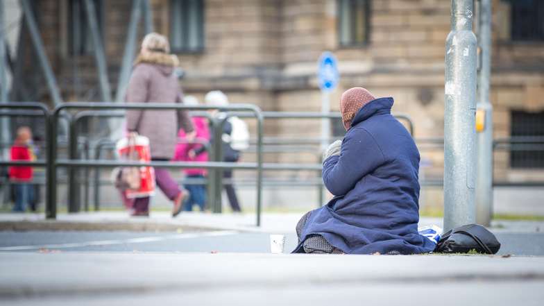 Ein Bettler wartet auf dem Pirnaischen Platz in Dresden darauf, dass Passanten Geld in seinen Becher werfen.