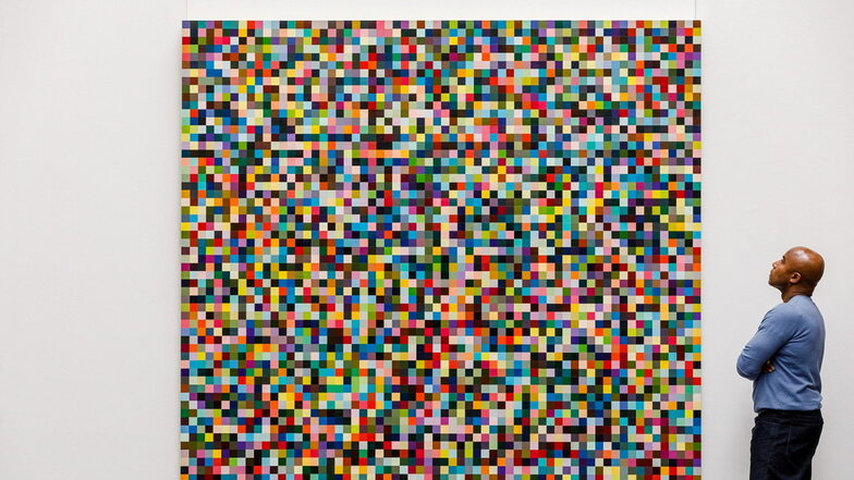 Ein Angestellter des Auktionshaus Sotheby's betrachtet das Gemälde "4096 Farben" des deutschen Künstlers Gerhard Richter.