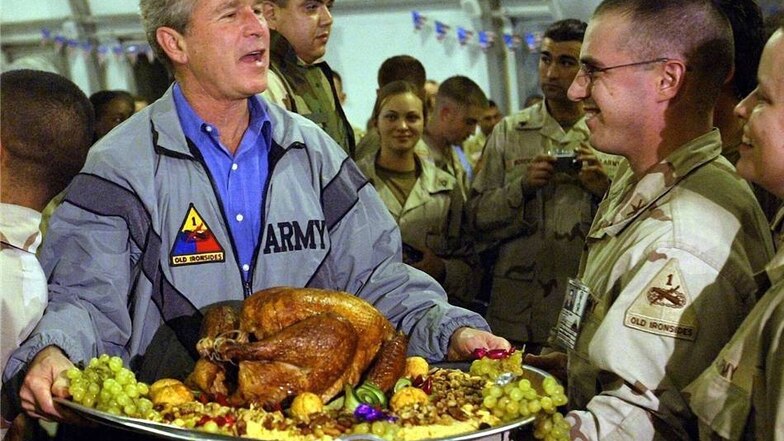 Eines der bekanntesten Fotos von Anja Niedringhaus: US-Präsident George W. Bush hält am 27. November 2003 auf dem Flughafen von Bagdad bei einem Thanksgiving-Essen mit etwa 600 Soldaten eine Platte mit einem Dekorations-Truthahn in Händen.