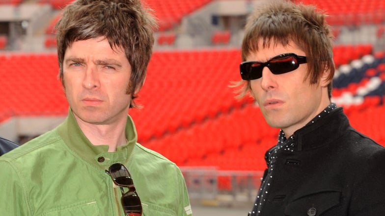 Die Oasis-Bandmitglieder Noel (links) und Liam Gallagher stehen während eines Fototermins im Wembley-Stadion. Die Britpopband Oasis plant ein Comeback.