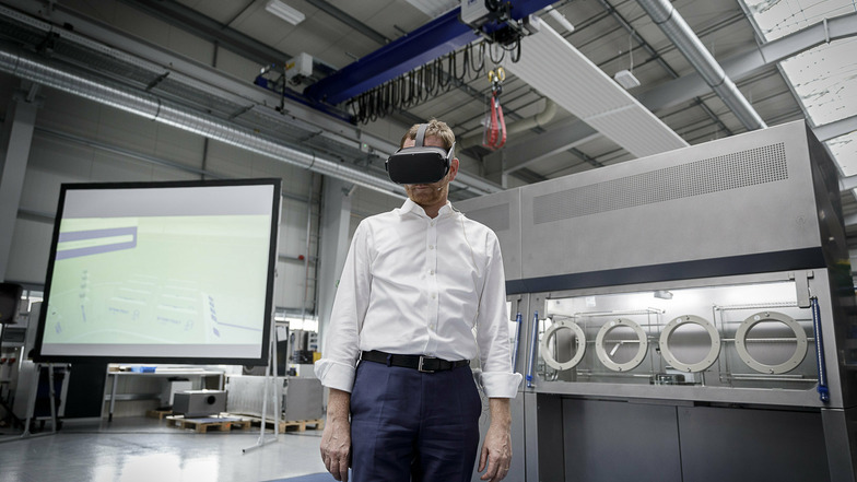 Michael Kretschmer beim Besuch des Maschinen- und Anlagenbauers SKAN in Görlitz. Im Hintergrund einer der modernen Isolatoren und die Videoleinwand, wo man sieht, wie Kretschmer virtuell hantiert.