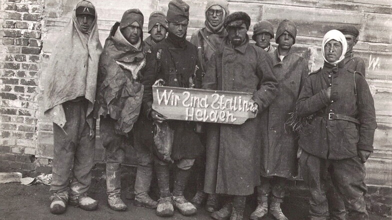 Sowjetische Kriegsgefangene müssen dieses Schild halten, auf dem sie als "Stalins Helden" verspottet werden.