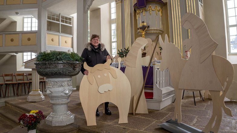 Katrin Jordan, Gemeindepädagogin der Kirchgemeinde Uhyst, zeigt einen Ochsen aus Holz, sowie Joseph und Maria auf dem Esel. Die Holzfiguren zieren nun die Kirche, in der auch dieses Jahr kein normales Weihnachtsfest möglich ist.