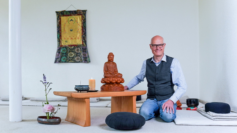 Bernd Groschupp im Meditationsraum. Auf dem Altar steht eine Buddha-Figur, daneben eine Schale mit Räucherstäbchen.