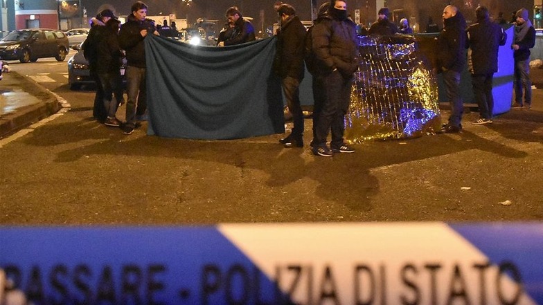 Polizisten sichern in Mailand am Morgen des 23. Dezember den Ort, an dem der mutmaßliche Lkw-Attentäter von Berlin von Polizisten erschossen worden war.