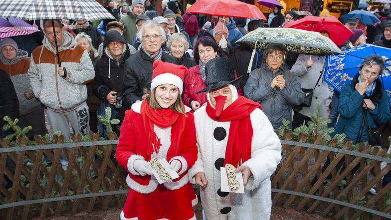 Zur offiziellen Eröffnung des Großenhainer Weihnachtsmarktes gibt es den traditionellen Stollenanschnitt. Wichtel Carolin Türke und Schneemann Mario Raue verteilen die begehrten Stücke.
