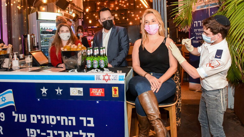 Eine junge Frau wird in Tel Aviv in einer Bar im Zentrum der Stadt geimpft. Die Stadtverwaltung von Tel Aviv bietet jedem, der sich dort impfen lässt, ein Freigetränk an.