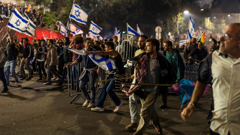 Israelische Regierungsgegner blockieren eine Straße, als sie gegen die Entlassung von Galant protestieren.