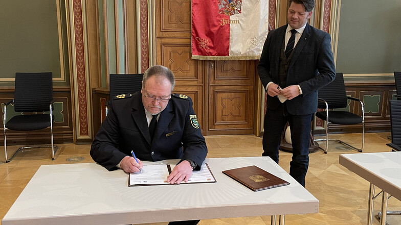 Polizeipräsident Manfred Weißbach beim Unterzeichnen der Vereinbarung. Neben ihm Zittaus Oberbürgermeister Thomas Zenker.