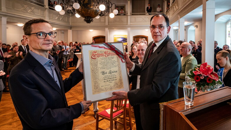 Der ehemalige Bürgermeister Veit Lindner (links) hat beim Neujahrsempfang in Roßwein am Freitagabend aus den Händen seines Nachfolgers Hubert Paßehr diese Urkunde entgegengenommen. Damit ist er zum Ehrenbürger ernannt worden.