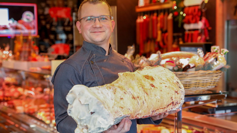 Fleischermeister Sebastian Herzog mit einem großen Stück Rindfleisch, dass mehrere Tage in einem Spezialschrank für eine noch bessere Geschmacksnote gereift ist.