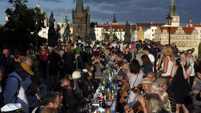 Eng beisammen, ohne Maske, ausgelassen feiernd. Am 30. Juni feiern Tschechen auf der Prager Karlsbrücke an einem 500 Meter langen Tisch das Ende der Corona-Maßnahmen.