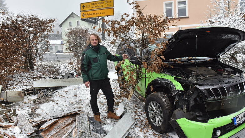 Knut Göhler steht neben seinem beschädigten Pickup und zeigt ein Stück Hecke, das bei der Unfallfahrt abgerissen worden ist.