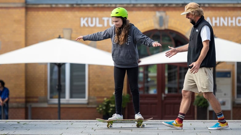 Skater Philipp Kern zeigt Elisabeth vorm Kultur-Bahnhof das Skaten. In der Mitmach-Erlebniswoche gehört eine Skateboard-Academy zum Programm.